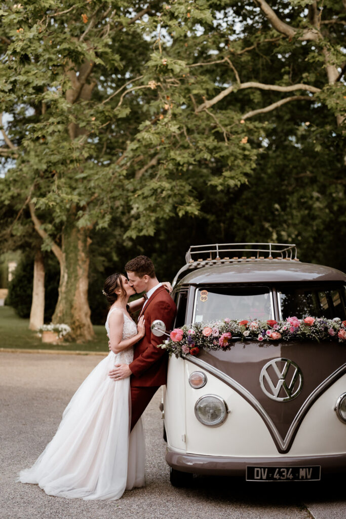 Mariés adossé à un combi Volkswagen lors de leur mariage au château de Malmont dans la région de Montpellier - photographie de mariage